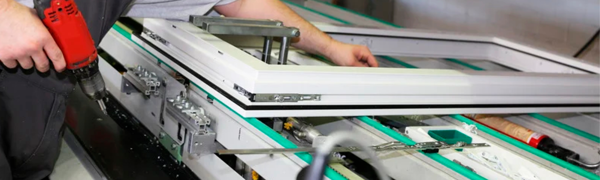 Imagen de un operario utilizando una herramienta eléctrica sobre un perfil de aluminio en un banco de trabajo